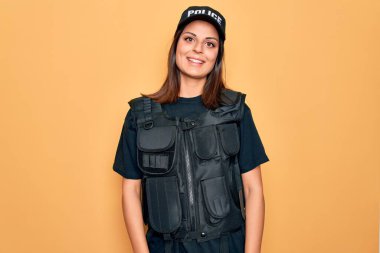 Genç ve güzel esmer kadın polis üniforması giyiyor kurşun geçirmez ve yüzünde mutlu ve havalı bir gülümseme olan bir şapka. Şanslı kişi..