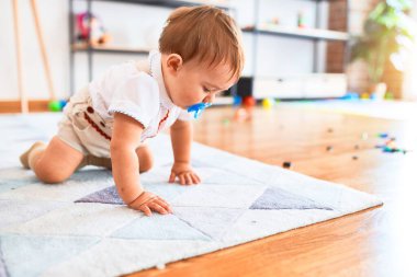 Anaokulunda bir sürü oyuncakla oynayan sevimli bir çocuk.