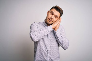 Mavi gözlü genç iş adamı soyutlanmış arka planda ayakta uyur. Yorgun düşler kurar, ellerle poz verir ve gözleri kapalı gülümserdi..