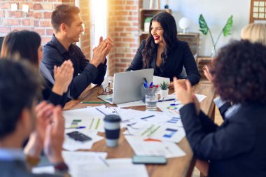 Group of business workers smiling happy and confident. Working together with smile on face applauding one of them at the office