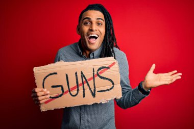 Afrika kökenli Amerikalı genç bir adam elinde Rastalı bayrak, yasaklanmış silahlar taşıyor. Çok mutlu ve heyecanlı, kazanan yüz ifadesi zaferi büyük bir gülümsemeyle kutluyor ve ellerini kaldırıyor.