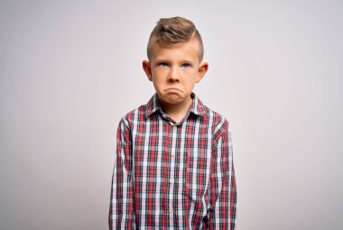 Mavi gözlü, genç beyaz bir çocuk izole edilmiş arka planda duran zarif bir gömlek giyiyor. Depresyonda ve üzüntüden ağlıyor, kızgın ve korkmuş. Üzücü ifade.
