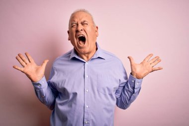 Orta yaşlı yakışıklı, beyaz gömlekli, pembe arka planda dikilmiş, çılgın ve çılgın başarısını kollarını kaldırıp, heyecanlı çığlıklar atarak kutluyor. Kazanan konsept