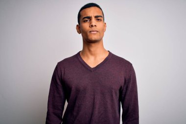 Beyaz arka plan üzerine gündelik kazak giyen genç ve yakışıklı Afro-Amerikan adam depresif ve endişeli, sinirli ve korkmuş. Üzücü ifade.