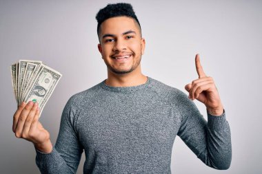 Soyutlanmış beyaz bir zemin üzerinde banknotlar tutan genç yakışıklı bir adam bir fikir ya da soru işareti ile şaşırdı mutlu bir yüz, bir numara