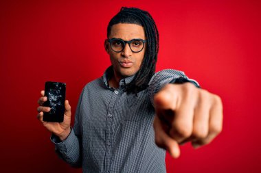 Kırık akıllı telefon tutan Afro-Amerikan genç adam kamerayı işaret eden kırık ekranı gösteriyor ve sen, el işareti, ön taraftan pozitif ve kendinden emin bir hareket.