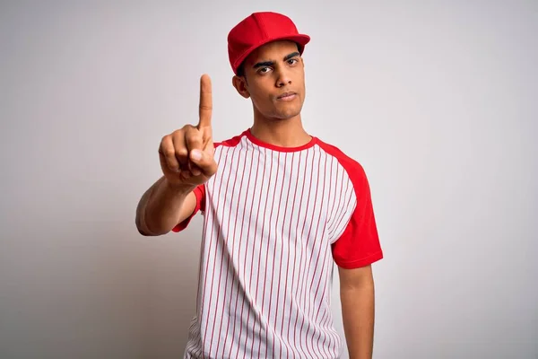 若いハンサムなアフリカ系アメリカ人のスポーツマンは ストライプの野球Tシャツとキャップを身に着けています指を指差すと怒りの表情 ジェスチャーを示しません — ストック写真