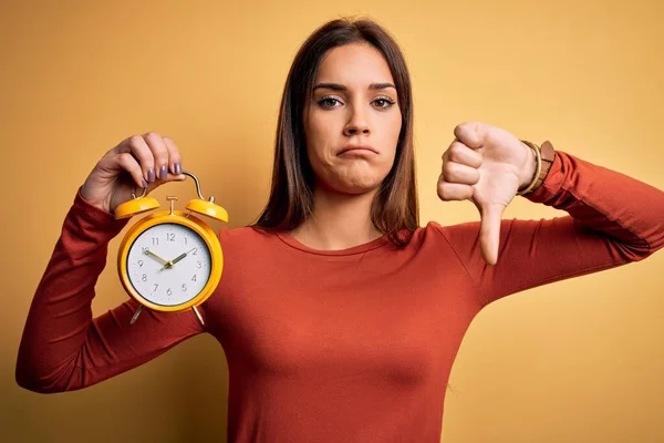 Jeune Belle Femme Brune Tenant Réveil Sur Fond Jaune Isolé — Photo