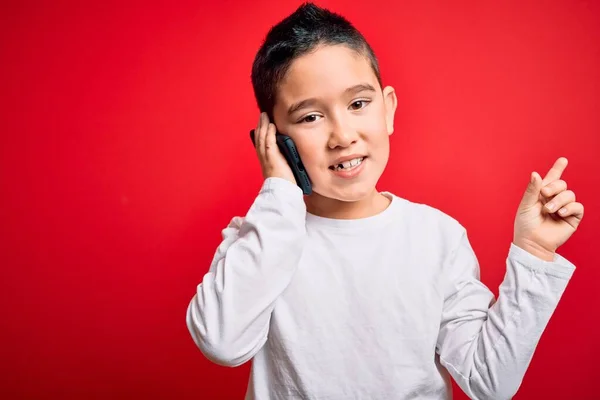 Niño Pequeño Hablando Teléfono Inteligente Móvil Sobre Fondo Rojo Aislado — Foto de Stock