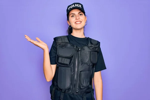 年轻的女警察身穿紫色背景的防弹背心制服 笑容满面 手牵手看着摄像机 — 图库照片