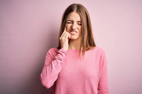 歯の痛みや歯の病気のために痛みを伴う式で手で口に触れる孤立したピンクの背景にカジュアルなセーターを着て若い美しい赤毛の女性 歯医者 — ストック写真