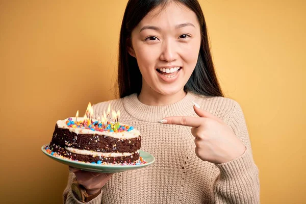 Junge Asiatische Frau Hält Geburtstagstorte Mit Brennenden Kerzen Über Gelbem — Stockfoto