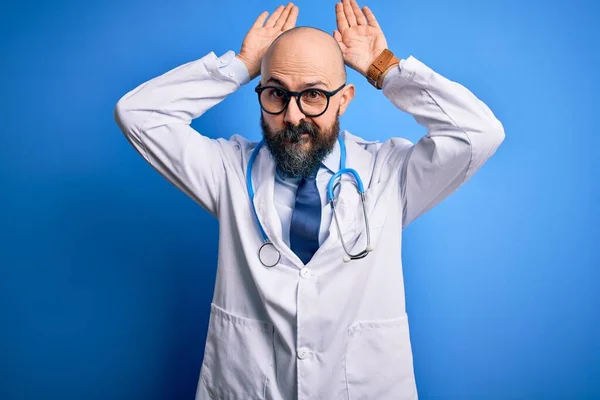 Przystojny Łysy Lekarz Brodą Noszący Okulary Stetoskop Niebieskim Tle Wykonujący — Zdjęcie stockowe