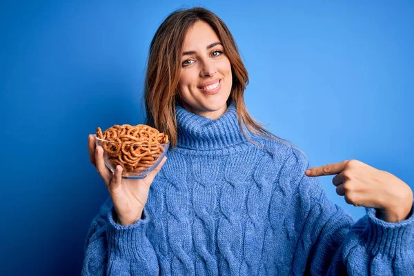 Young Beautiful Brunette Woman Holding Bowl German Baked Pretzels Blue — Stock Photo, Image