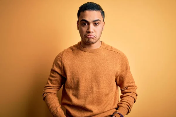 孤立した黄色の背景の上に立ってカジュアルなセーターを着て若いブラジル人の男性落ち込んで 苦痛を心配し 怒っていると恐れて泣いている 悲しい表情 — ストック写真