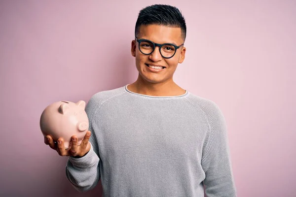 Jovem Bonito Latino Homem Segurando Porquinho Banco Sobre Isolado Fundo — Fotografia de Stock