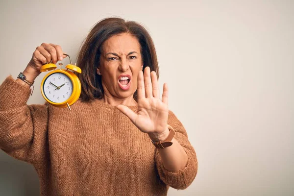 Medelålders Brunett Kvinna Håller Clasic Väckarklocka Över Isolerad Bakgrund Gör — Stockfoto