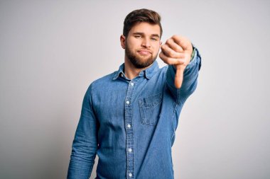 Sakallı, mavi gözlü, sıradan bir kot gömlek giyen, mutsuz, sinirli, reddedilmiş ve olumsuz jestli genç, yakışıklı sarışın bir adam. Kötü ifade.