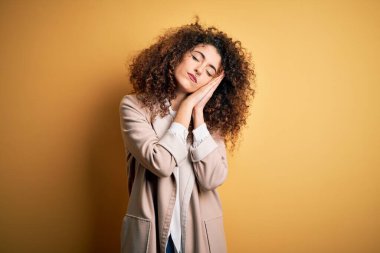 Kıvırcık saçlı ve piercingli genç ve güzel bir kadın. Günlük tişört giyiyor ve Diadem giyiyor. Yorgun uyuyor..