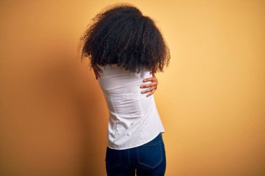 Sarışın, Afro saçlı, güzel, Afro-Amerikan zarif bir kadın. Kendine sarılıyor, mutlu ve pozitif. Sevgi ve özgüven.