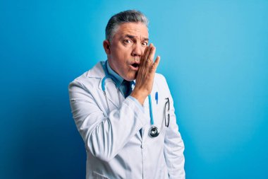 Orta yaşlı, yakışıklı, gri saçlı doktor. Palto giymiş, mavi steteskop takmış. Gizli söylentiler yayıyor.