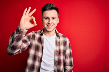 Kırmızı izole edilmiş arka plan üzerine gündelik modern tişört giyen yakışıklı beyaz adam el ve parmaklarıyla 