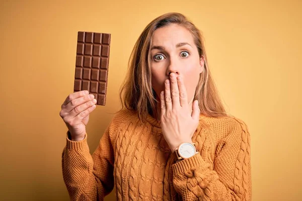 Junge Schöne Blonde Frau Hält Schokoriegel Über Isoliertem Gelben Hintergrund — Stockfoto