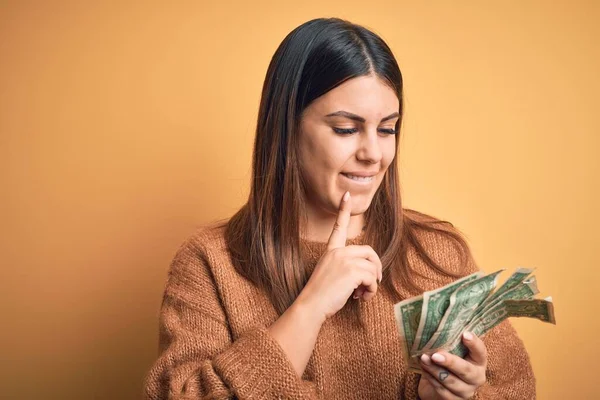 Jovem Mulher Bonita Segurando Dólares Sobre Fundo Laranja Isolado Rosto — Fotografia de Stock