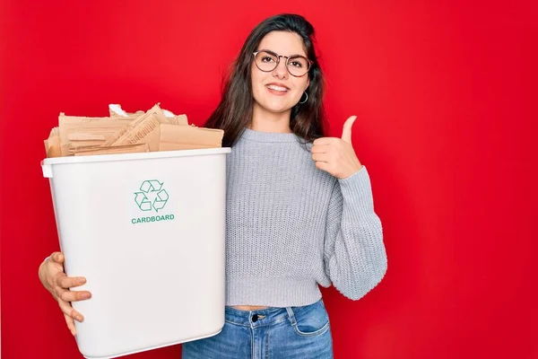 エコ環境のためのリサイクル段ボール容器リサイクルを保持している若い美しい女性大きな笑顔で幸せなOkサインを行う 指で親指アップ 優れたサイン — ストック写真