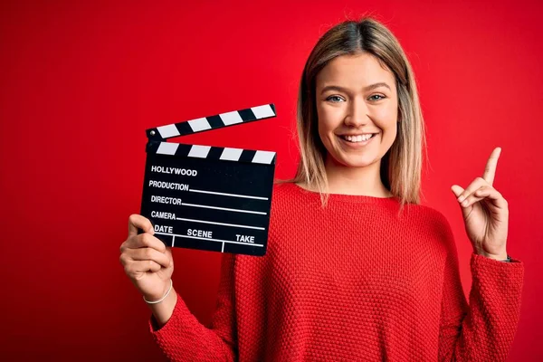 Ung Vacker Kvinna Som Håller Clapboard Stående Över Isolerad Röd — Stockfoto