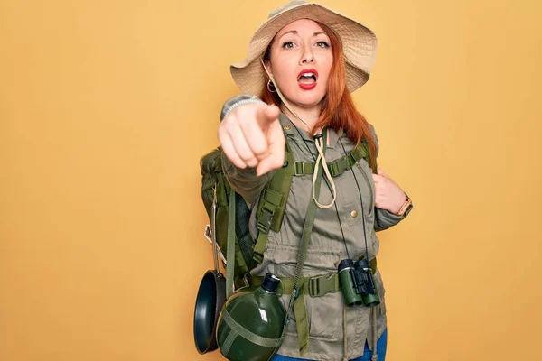 Молодая Рыжая Женщина Турист Походы Рюкзаке Шляпе Желтом Фоне Указывая — стоковое фото