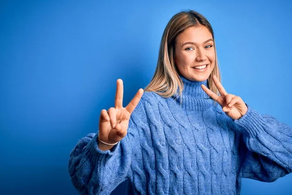 Ung Vakker Blond Kvinne Med Vinterullgenser Blå Isolert Bakgrunn Smiler – stockfoto