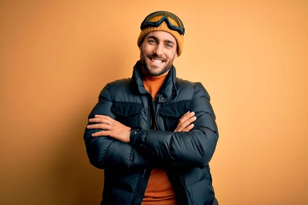 Kar Giysileri Kayak Gözlüğü Takan Kollarını Kavuşturup Kameraya Gülümseyen Genç — Stok fotoğraf