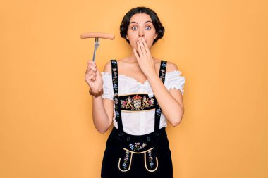 Mavi gözlü genç Alman kadın elinde çatalla sosis kaplı bir elbise giyiyor. Ağzı ve elleri hata yüzünden şoke olmuş. Korkunun ifadesi, sessizlikten korkmak, gizli konsept.
