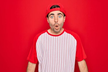 Mavi gözlü, çizgili beysbol tişörtü ve şapkası giyen genç yakışıklı sporcu, korku ve heyecan dolu yüz ifadesiyle korkmuş ve şok olmuştu..