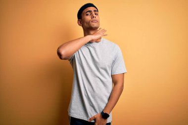 Yakışıklı Afro-Amerikan sporcusu spor giyer sarı arka plan üzerine spor giyer bıçakla boğazını keser, saldırganlığı şiddetle tehdit eder.