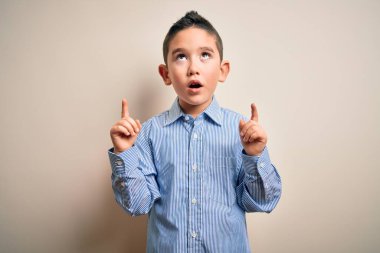 Zarif bir gömlek giyen küçük bir çocuk. Arka planda duruyordu. Şaşırmış ve şaşırmıştı..