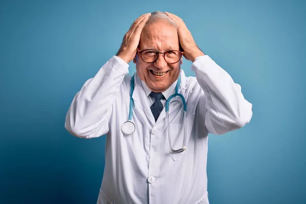 Starszy Siwy Lekarz Noszący Stetoskop Płaszcz Medyczny Niebieskim Tle Cierpiący — Zdjęcie stockowe