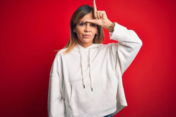 Middelbare Leeftijd Mooie Sportvrouw Dragen Casual Sweatshirt Geïsoleerde Rode Achtergrond — Stockfoto