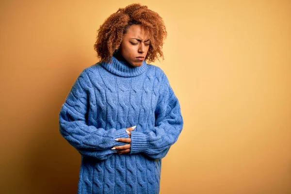 年轻美丽的非洲裔美国女人 卷曲的头发 身穿蓝色的高领毛衣 手放在肚子上 因为消化不良 痛苦的疾病感觉不舒服 阿切概念 — 图库照片