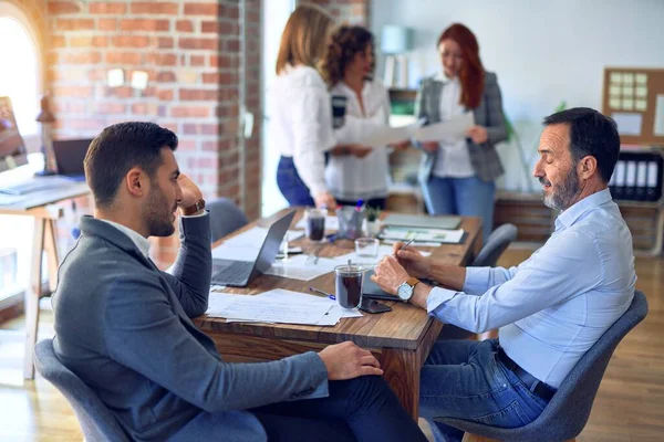 Handsome businessmen sitting and speaking relaxed at the office