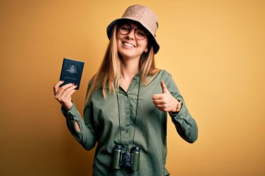 Sarışın, mavi gözlü, Avustralya pasaportlu, dürbün kullanan, gülümseyen, tamam yazan, parmaklarıyla başparmağını kaldıran sarışın bir turist.