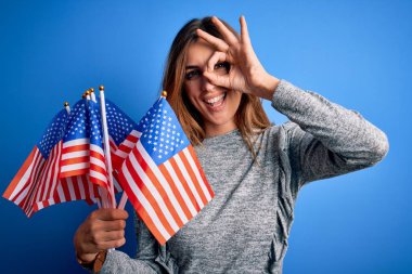 Amerika Birleşik Devletleri bayraklarını tutan genç, güzel, vatansever bir kadın mutlu yüzle bayrak kaldırıyor.