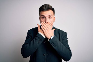 Soyutlanmış arka planda duran zarif kışlık ceketler giyen genç yakışıklı iş adamları yanlışlıkla ağızlarını kapatarak şok geçirdiler. Gizli konsept.
