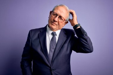 Gri saçlı, gözlüklü, şık takım elbiseli ve kravatlı kıdemli iş adamı. Mor arka plan karışıklığı ve soru sormayı merak ediyor. Şüpheyle kararsız, kafa kafaya düşünerek. Düşünceli kavram.
