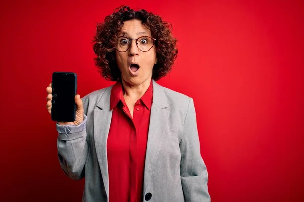 Middelbare Leeftijd Krullende Vrouw Met Smartphone Tonen Scherm Geïsoleerde Rode — Stockfoto