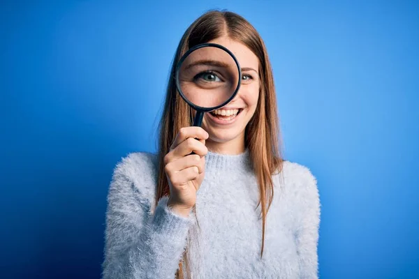 Jovem Bela Mulher Detetive Ruiva Usando Lupa Sobre Fundo Azul — Fotografia de Stock