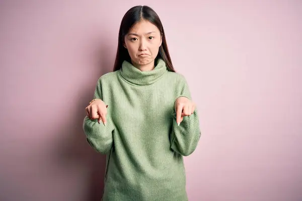 녹색의 스웨터를 아름다운 배경에 분홍빛 슬퍼하고 표정을 모습은 손가락 아프고 — 스톡 사진