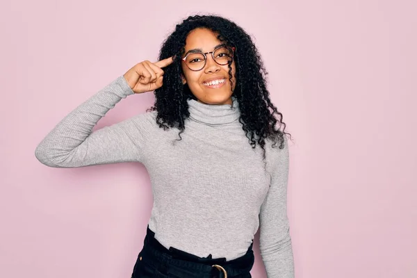 Młoda Afroamerykanka Swetrze Okularach Różowym Tle Uśmiechnięta Głowy Jednym Palcem — Zdjęcie stockowe