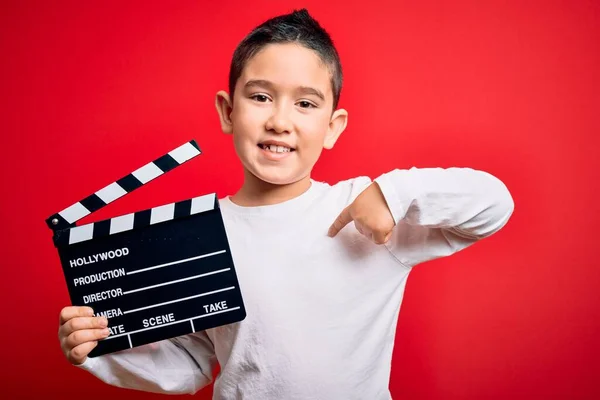 Młody Chłopiec Nagrywa Wideo Trzymając Reżysera Kina Clapboard Odizolowanym Czerwonym — Zdjęcie stockowe